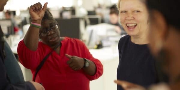 A group of people, one person is communicating using sign language.