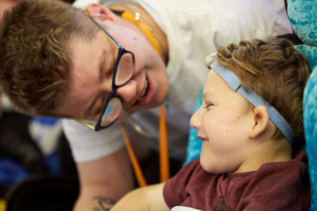 A close up of an adult and young child both smiling.