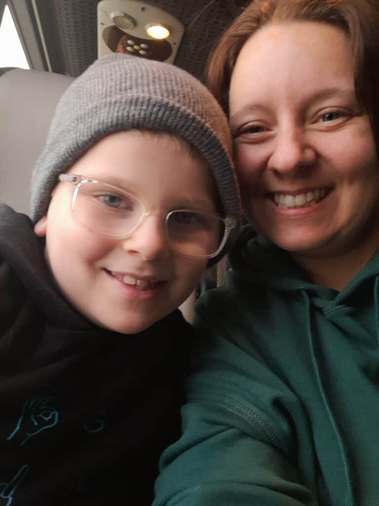 Catherine, a white woman with brown hair, smiling for a selfie with her son Marshall.