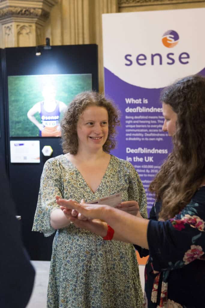 Olivia Blake MP being shown deafblind manual on her hand