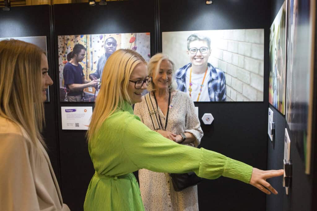 Visitor to exhibition has arm outstretched to push a button