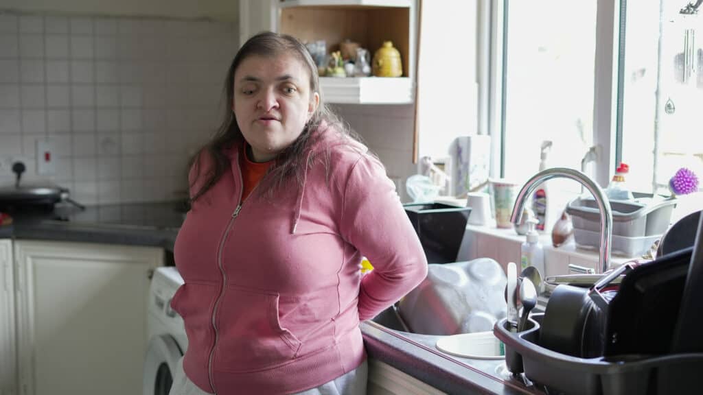 Charlotte stands in her kitchen