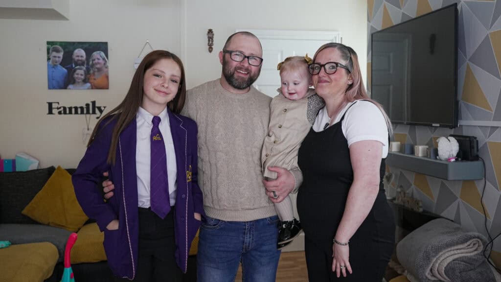 Natalie with her partner and two children in their home.