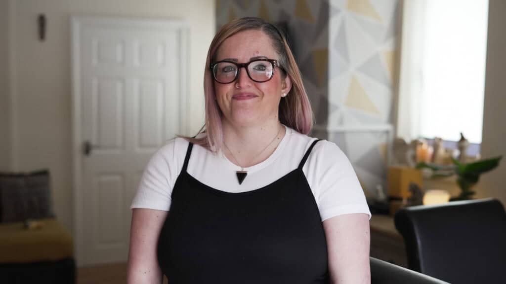 A close-up of Natalie, a white woman with blonde hair wearing glasses.