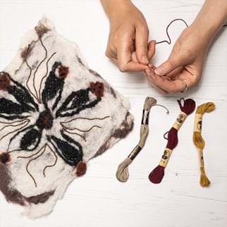 Embroidery thread of different colours and a pattern on fabric
