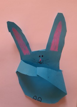 A blue cut out of an Easter bunny, in the shape of a handprint.
