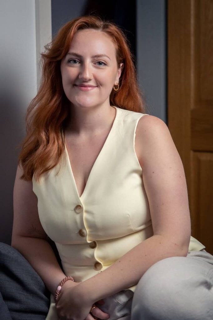 A headshot of a woman wearing a light-yellow waistcoat.