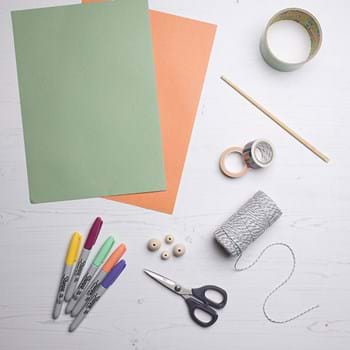 Coloured paper, felt tip pens, scissors, beads, string, colourful tape and a tape tube