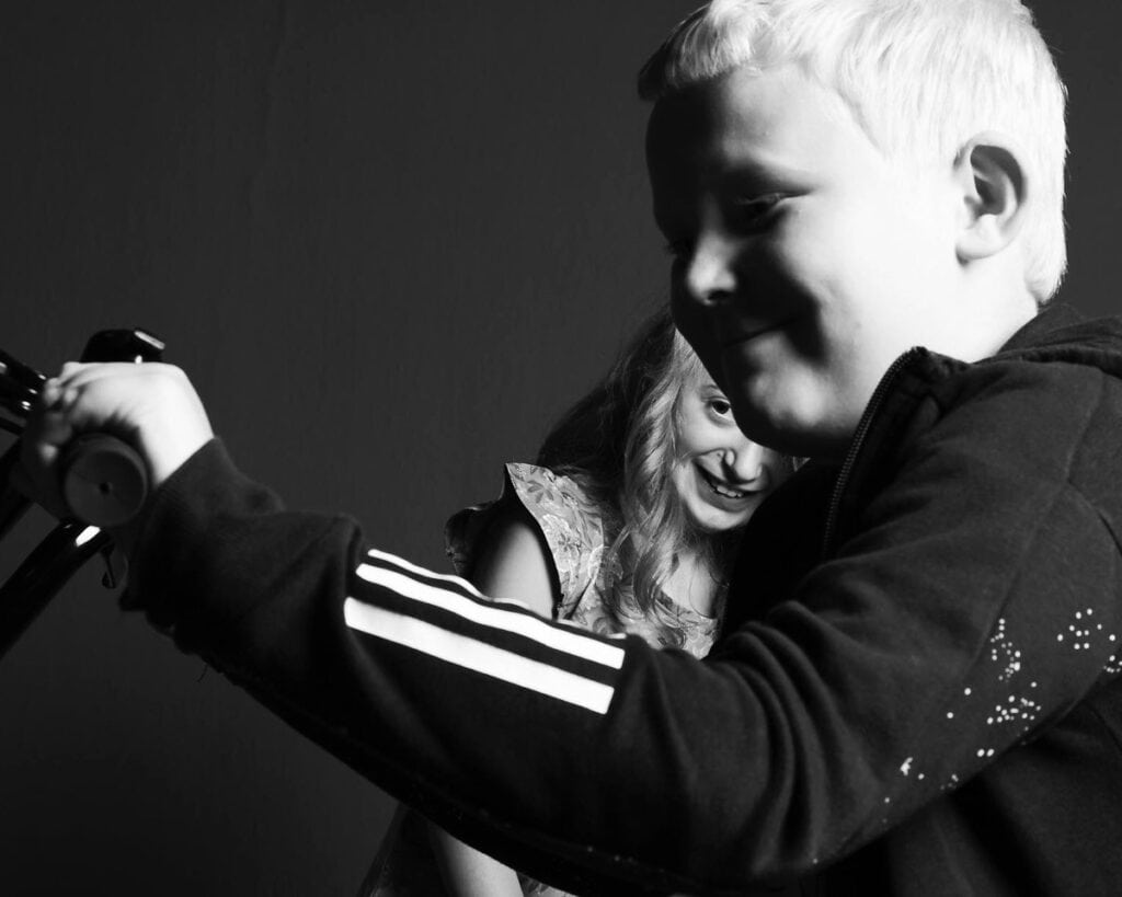 A young boy and girl laughing in black and white. Photo by Ian Treherne.