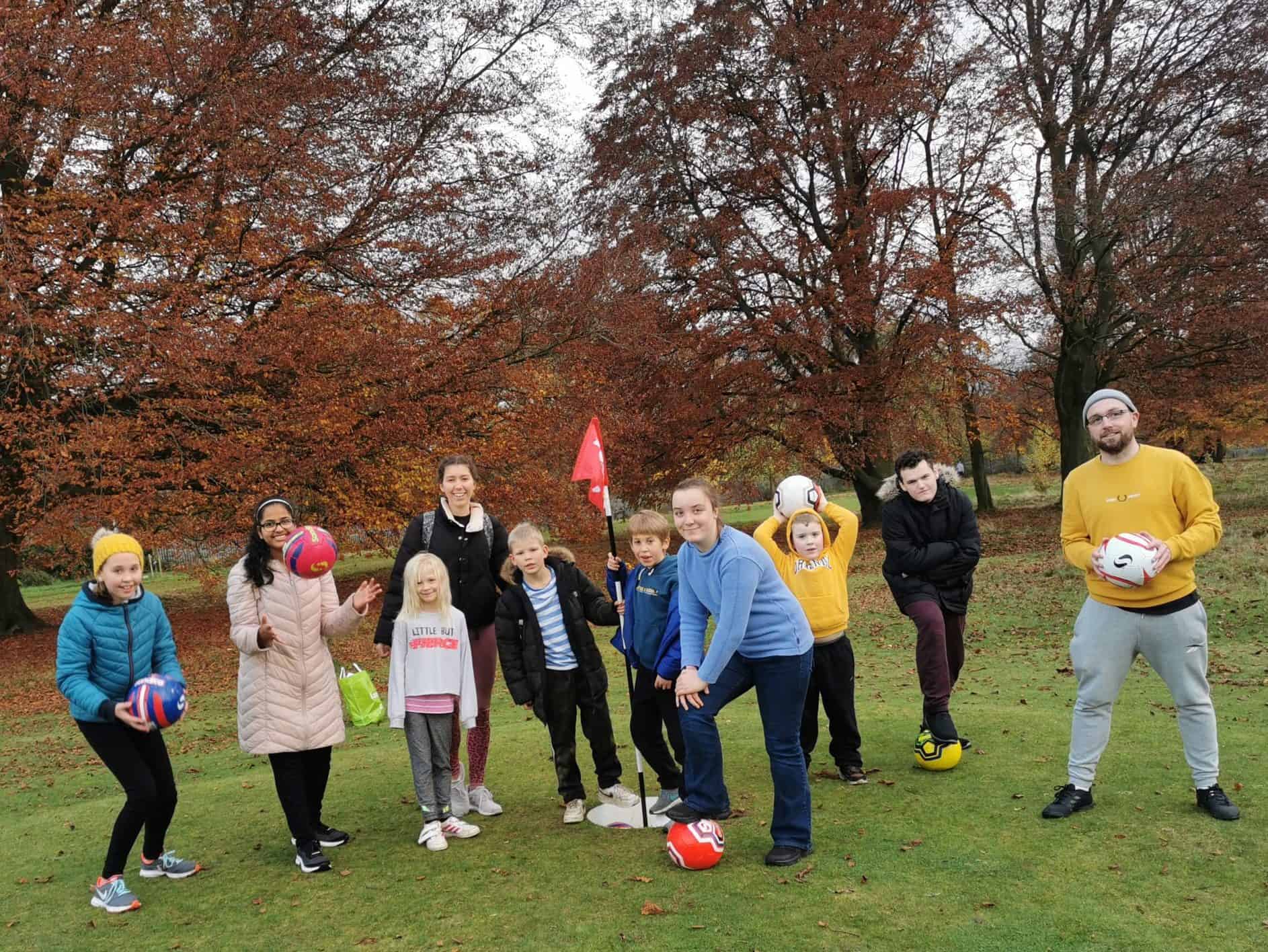 Jahnavi with a group of friends outside, smiling at the camera during a break from their football game