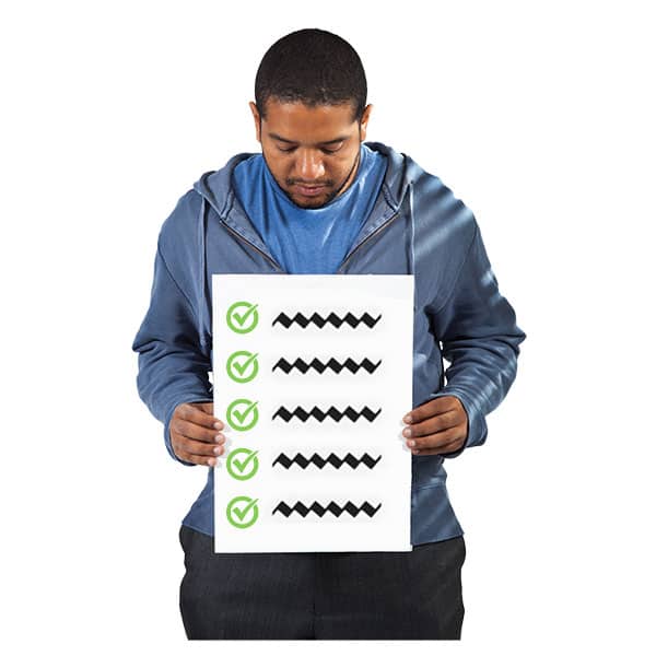 A man holds a sign with a series of ticked items on it