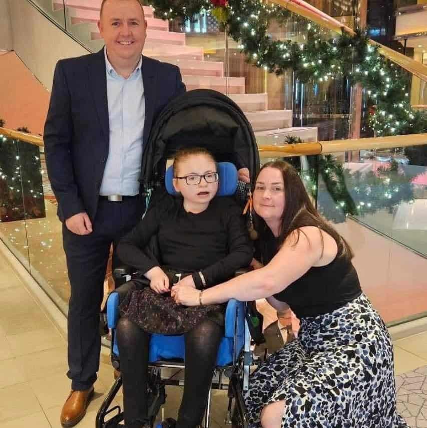 Megan with her mum Emma Stokes and dad Richard Dunwell on holiday last year. They are all dressed smartly and smiling widely.
