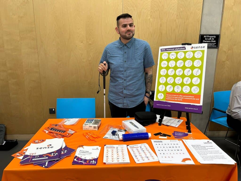 A man stands at a stall at Sense's accessible jobs fair