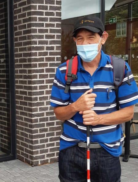 A man with a stripey blue top wearing a mask