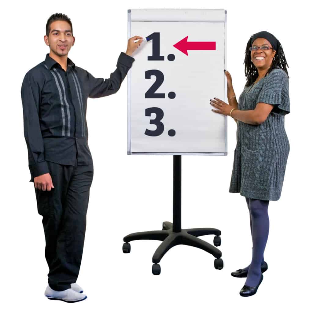 2 people in front of a flip chart. The flip chart has an arrow by the number 1