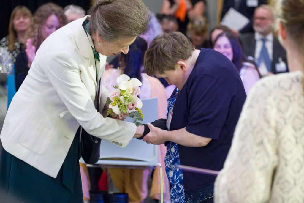 Princess Anne shaking hand of person we support