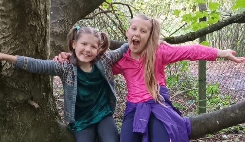Two young girls, Bryanna and friend, arm in arm pose for the camera