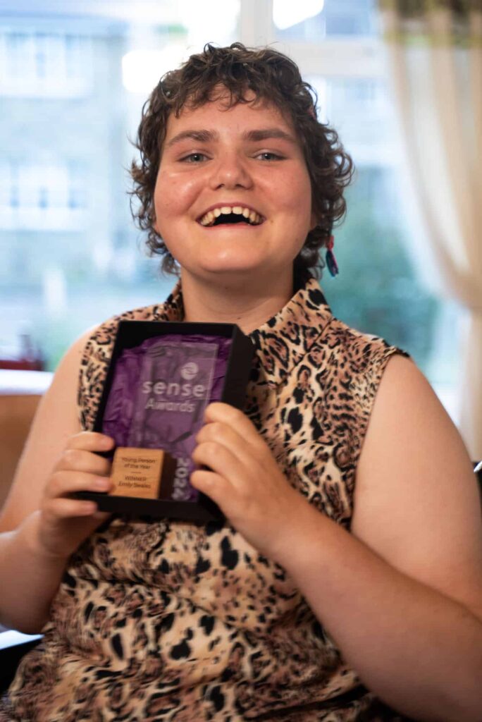 Emily grins as she holds her Sense Award.
