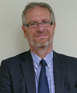 headshot of simon jones looking at the camera smiling