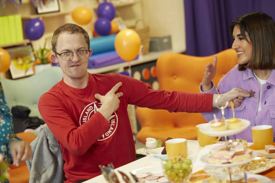 Young man signing at a tea party
