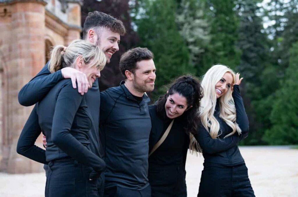 A group of people wearing black tops laughing with each other.