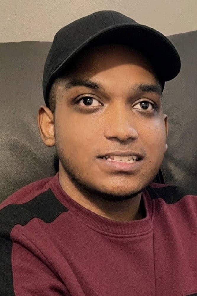 A young man in a baseball cap smiling at the camera