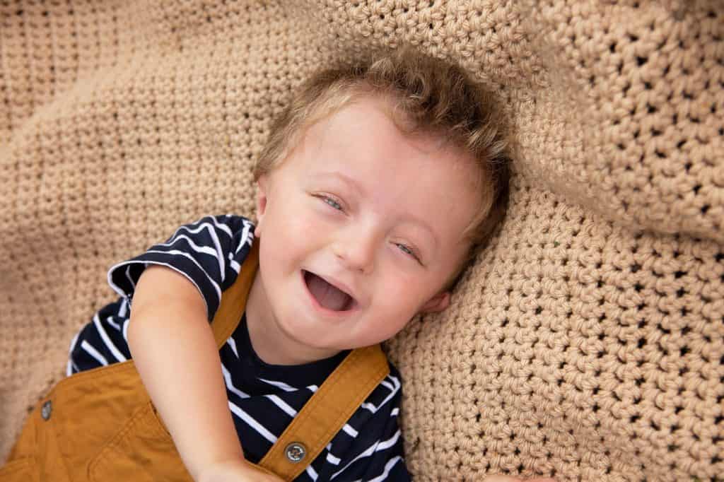 A little boy lying down, laughing